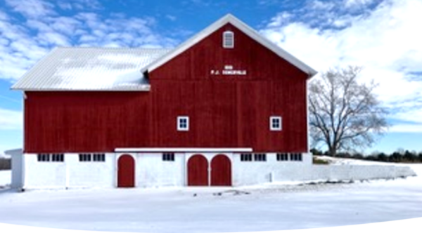 Red barn standing in a snow-covered rural landscape
